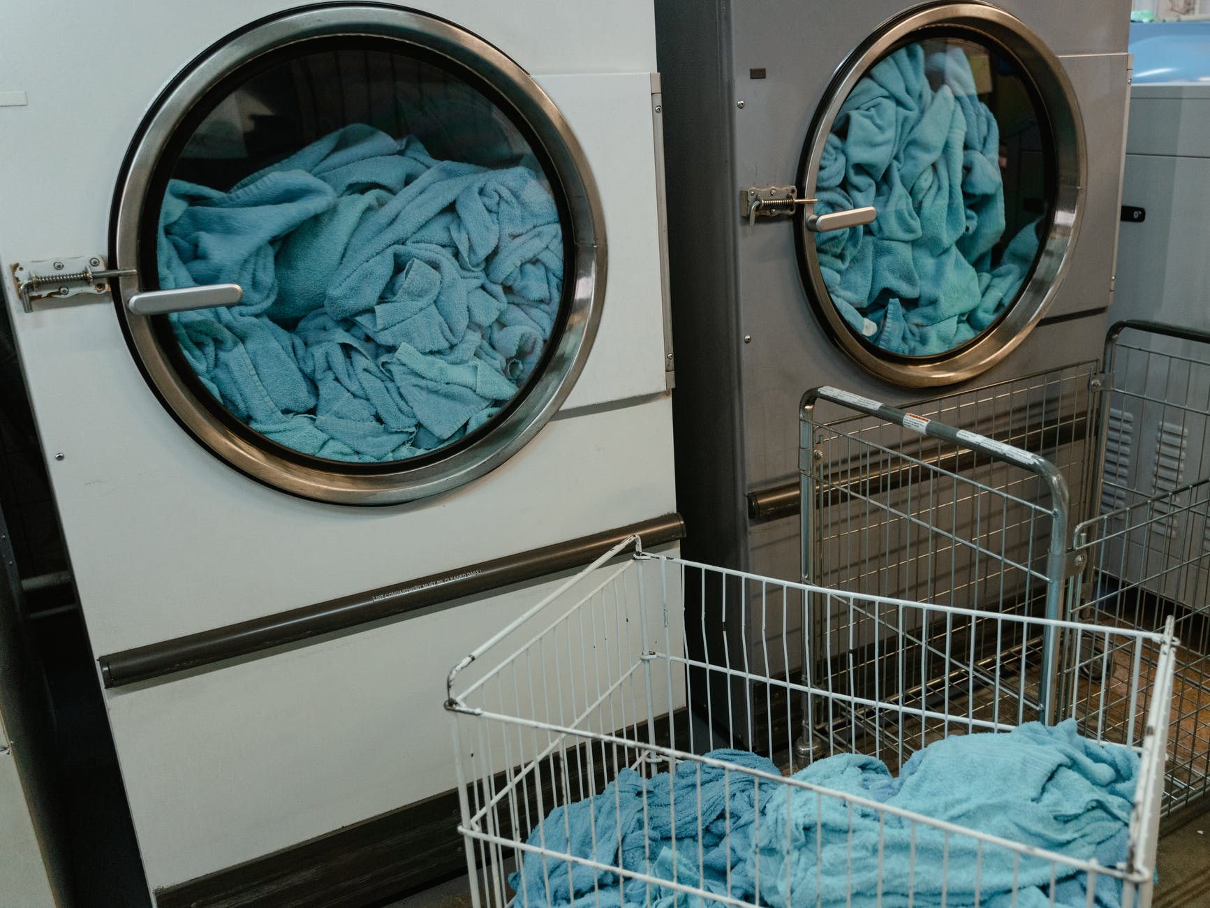 white and gray washing machine with blue fabrics inside